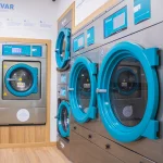 Espaço interior da lavandaria self-service Blue Lavandarias com máquinas de lavar e secar