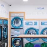 Espaço interior da lavandaria self-service Blue Lavandarias com máquinas de lavar e secar
