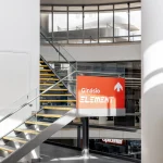 Escadas no Interior do Shopping com informação de localização do ginásio Element